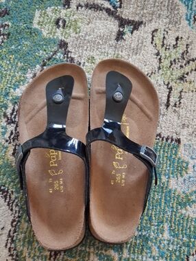 Papillio Black Patent Toe-Post Sandals with Gold Logo